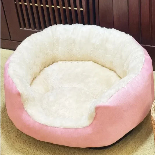 Pink and white pet bed on a carpeted floor with a wooden floor in the background